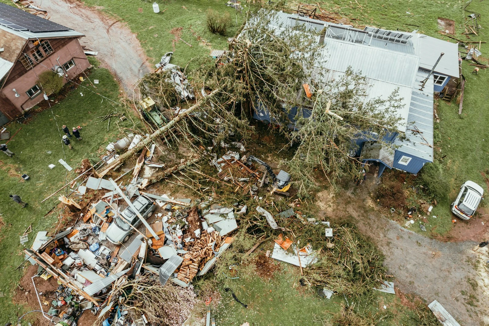 Aerial view of storm-damaged home with fallen trees