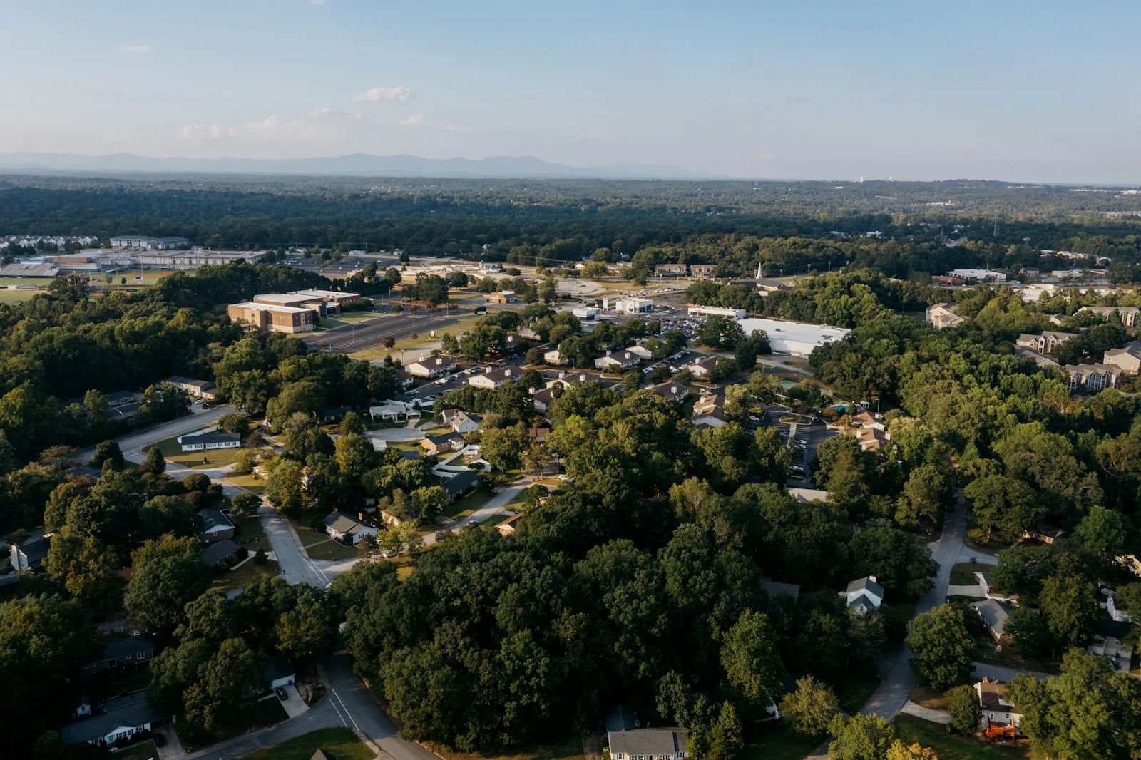 Aerial view of a suburban neighborhood surrounded by trees