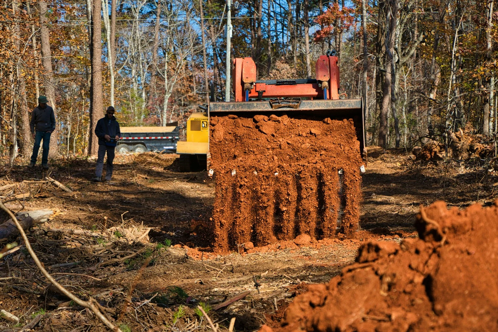 Excavator finishing site prep after commercial land clearing Daytona Beach