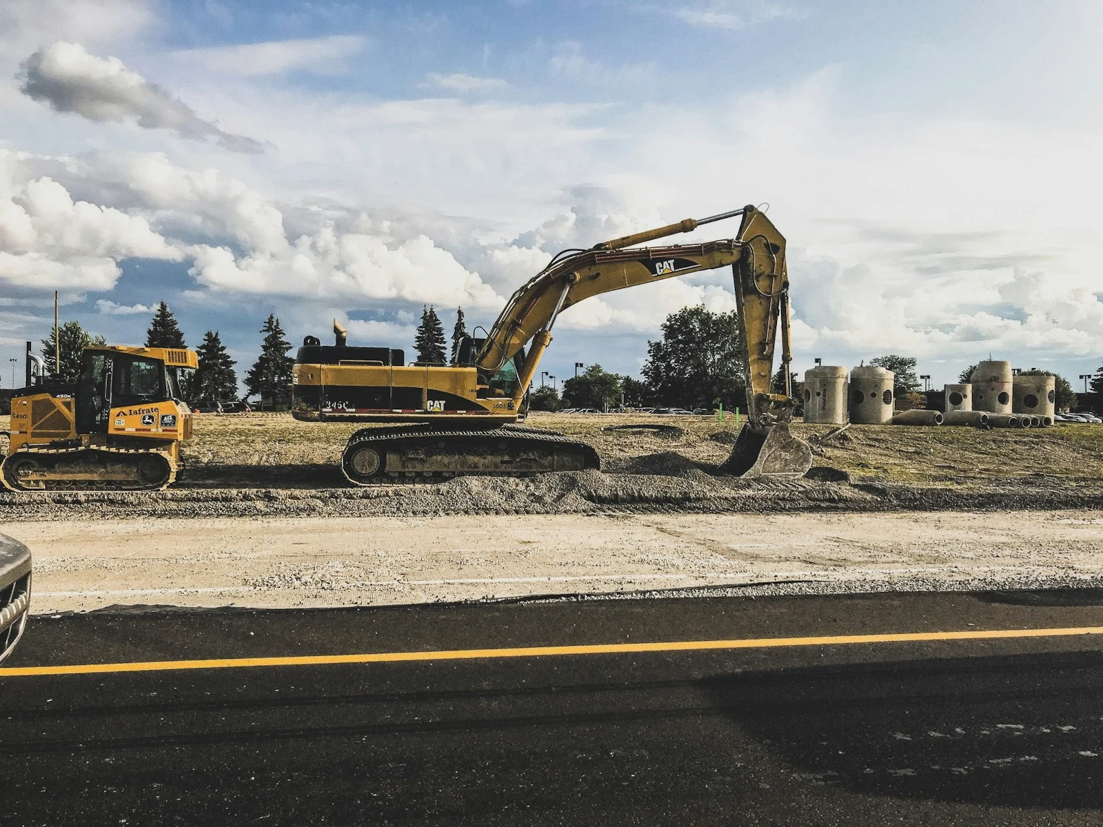 Yellow Caterpillar excavator digging up dirt during land clearing