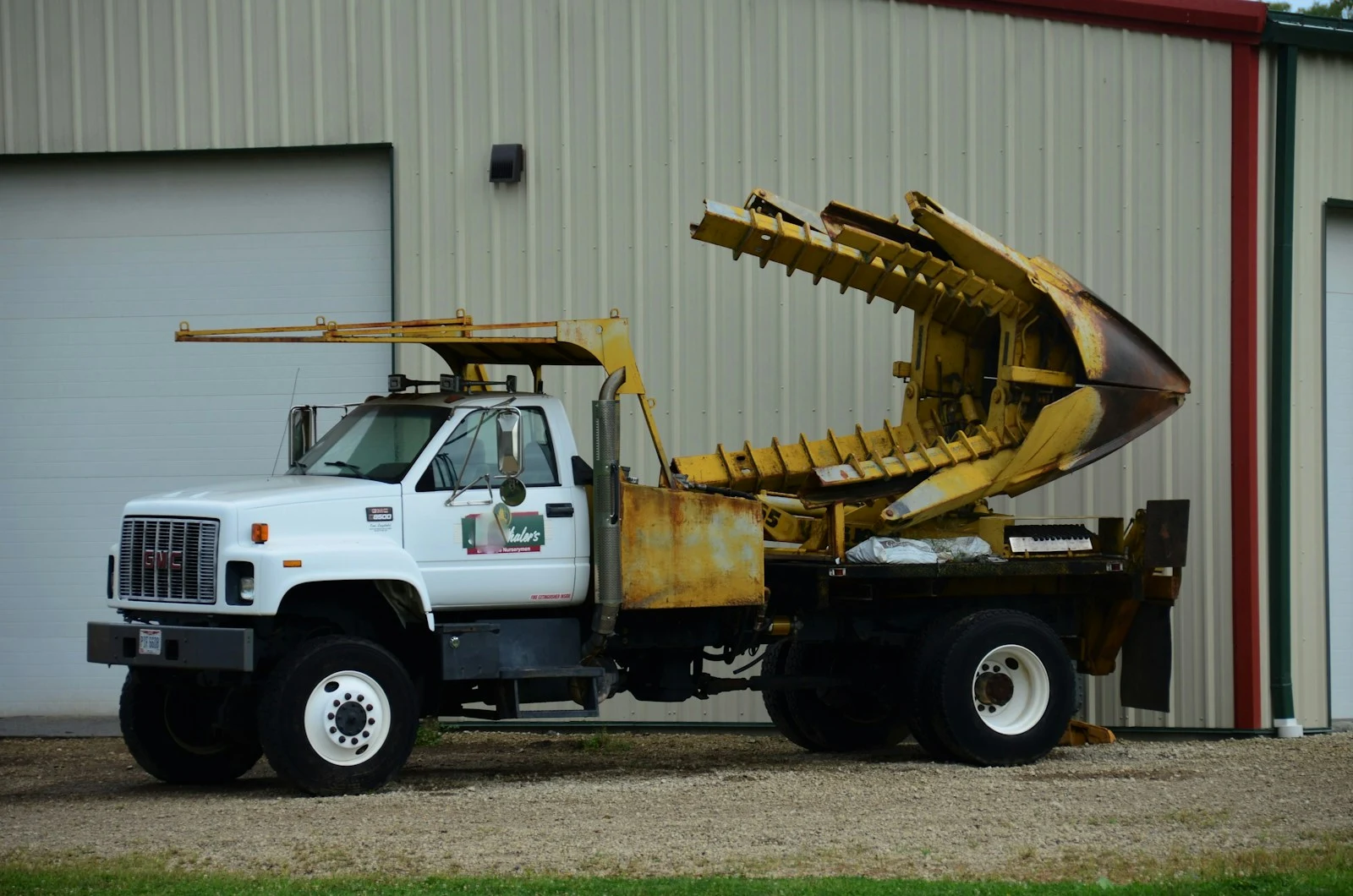 Grapple truck loading heavy debris and logs from a property