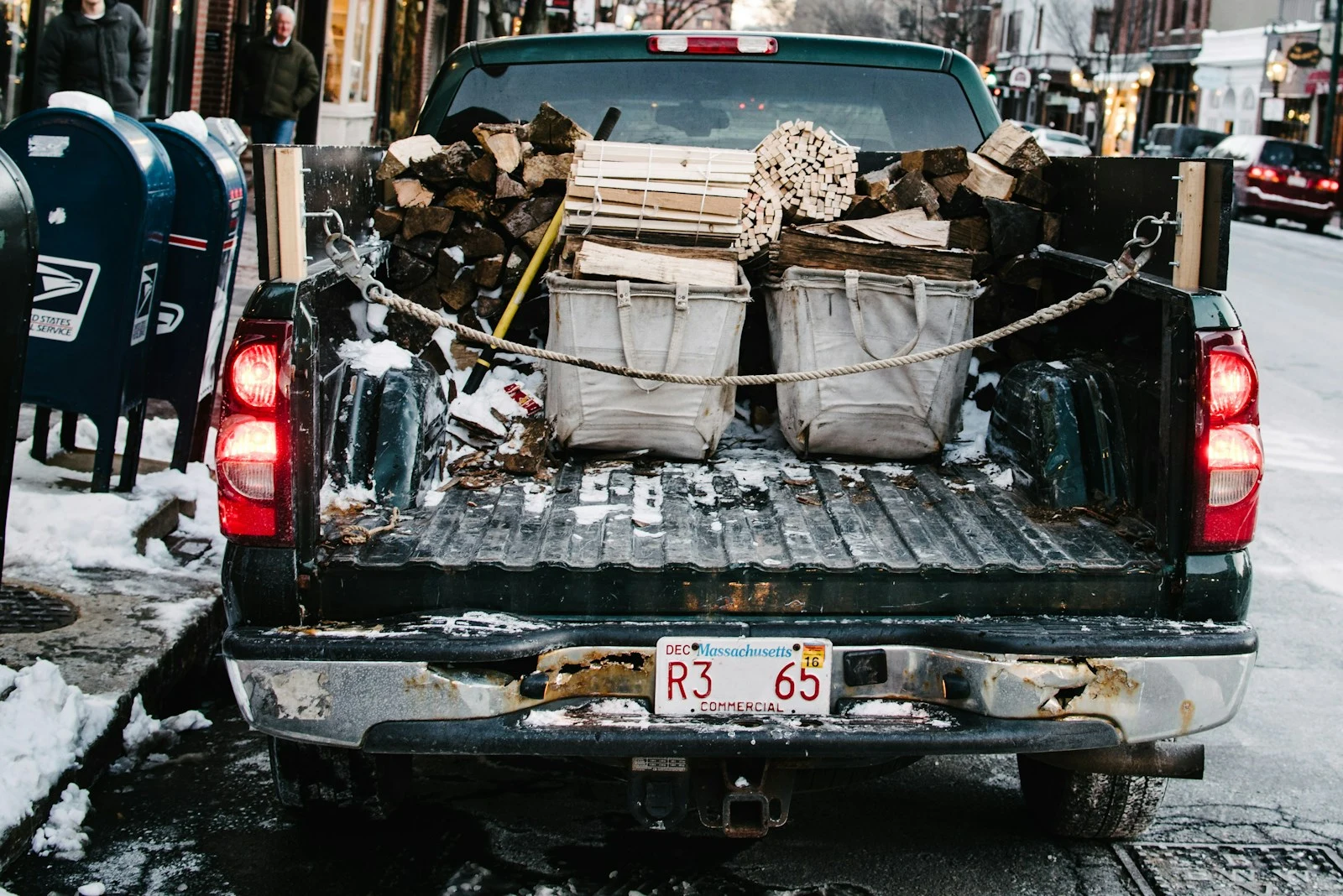Pickup truck loaded with firewood parked on concrete roadway