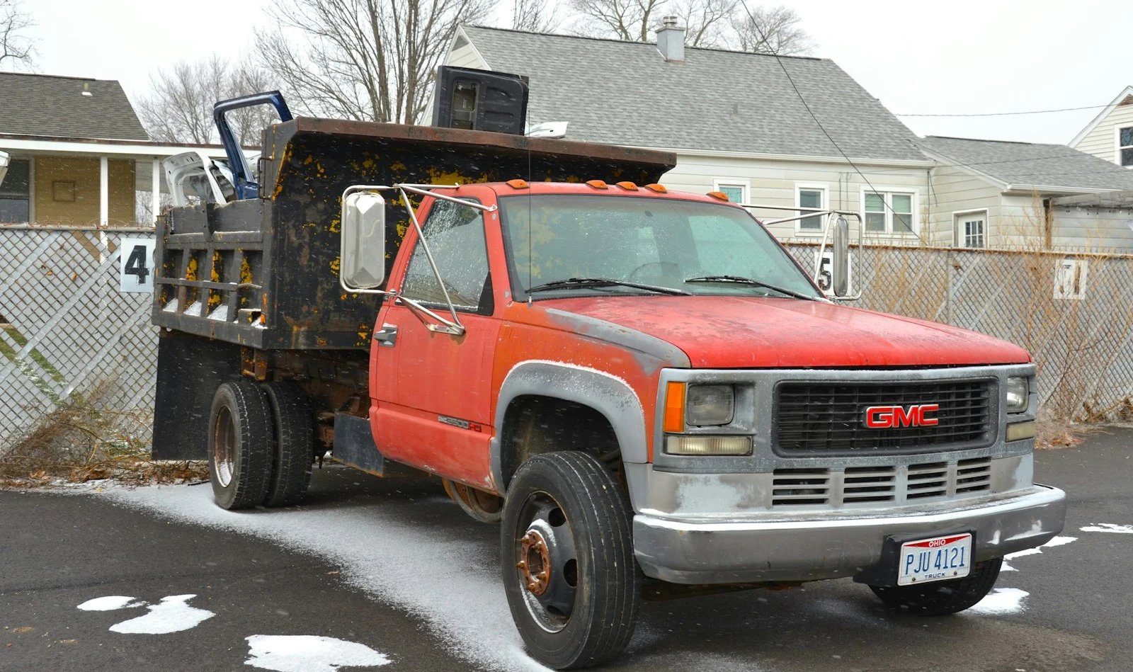 Red dump truck parked on road side for debris collection