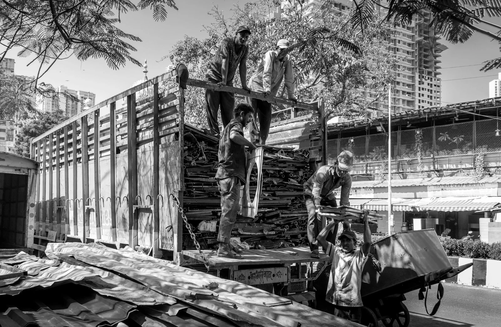 Workers loading yard debris onto a truck in a service area